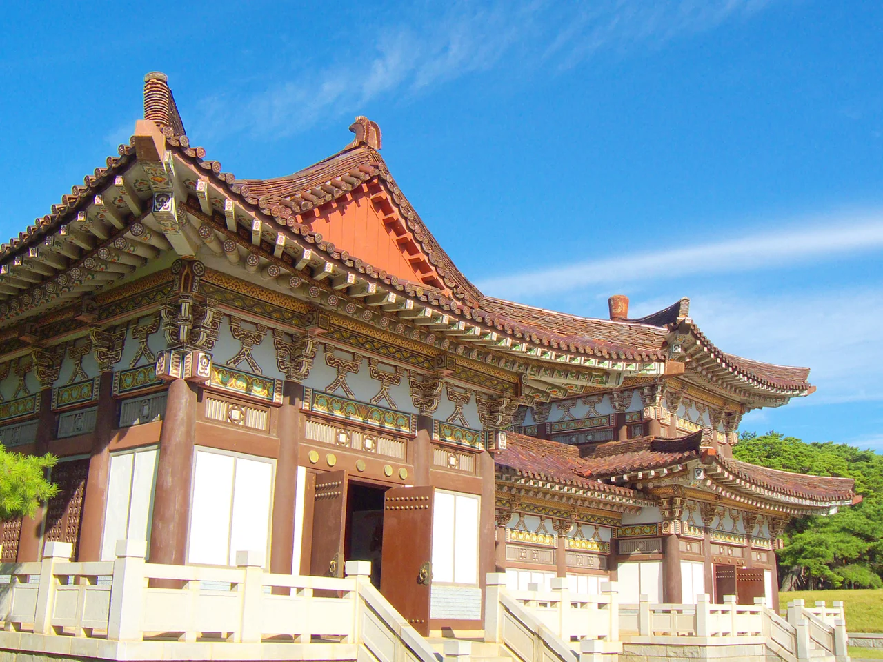 Eaves with dancheong paint at the Tomb of King Tongmyŏng, rural Pyongyang. 
The king was the founder of Goguryeo, one of the Three Kingdoms (the others being Silla and Baekje).
It is the associated building in front of the funerary statues and behind the arch. (This is not at the temple complex farther away.)

The elevated lawn in the background is the platform before the tomb.